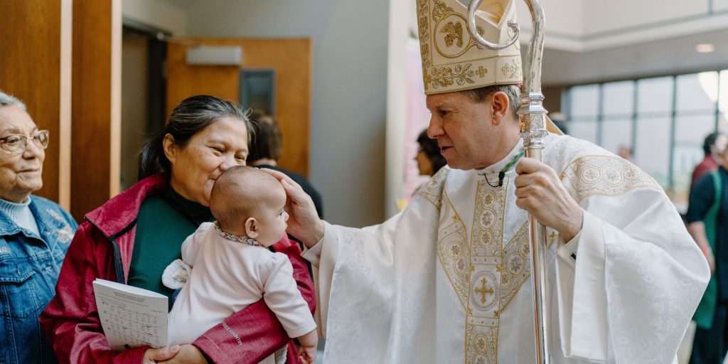 Bishop Spalding blessing a baby