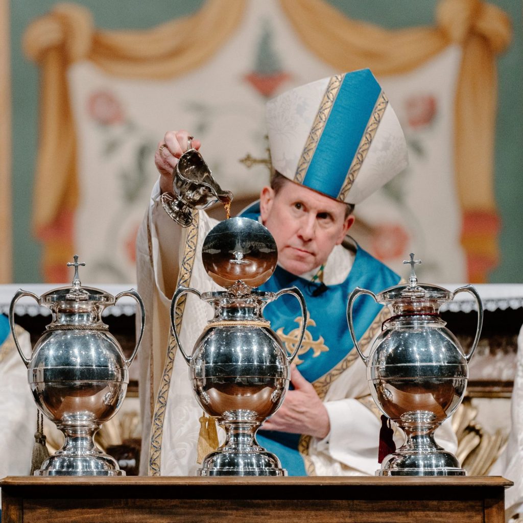 Bishop Spalding at Chrism Mass pouring holy oils